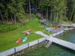 Dock w/ 8,000lb boat lift, firepit, deck w/ gazebo, chairs & table, and stairs into water